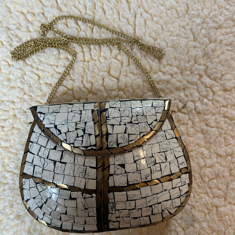 Handtiled handbag with gold chain.